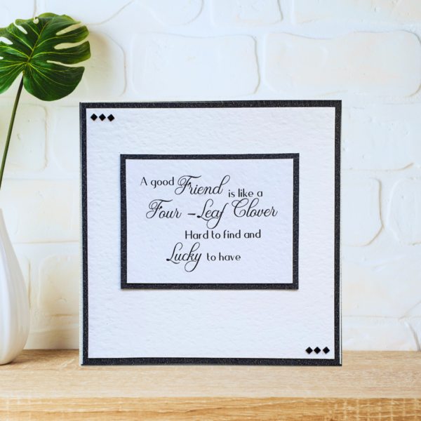 Black and white layered friendship quote card with beautiful crystals displayed on a wooden shelf in front of a white wall