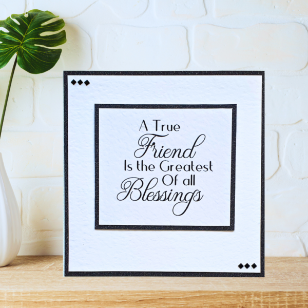 Black and white layered friendship quote card with beautiful crystals displayed on a wooden shelf in front of a white wall