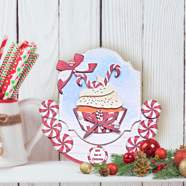 Festive treats rocker style card with peppermint cupcake displayed on a white shelf in front of a white wall. Sweet Peppermint Cupcake Festive treats rocker style card displayed on a white shelf in front of a white panelled wall.